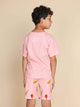 Achteraanzicht van een kind dat het SNURK Ice Cream Cones T-shirt Kids draagt met vrolijke shorts.