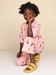 SNURK Ice Cream Cones Wide Pants Kids - Een meisje draagt een broek met ijsjes in een ontspannen houding.