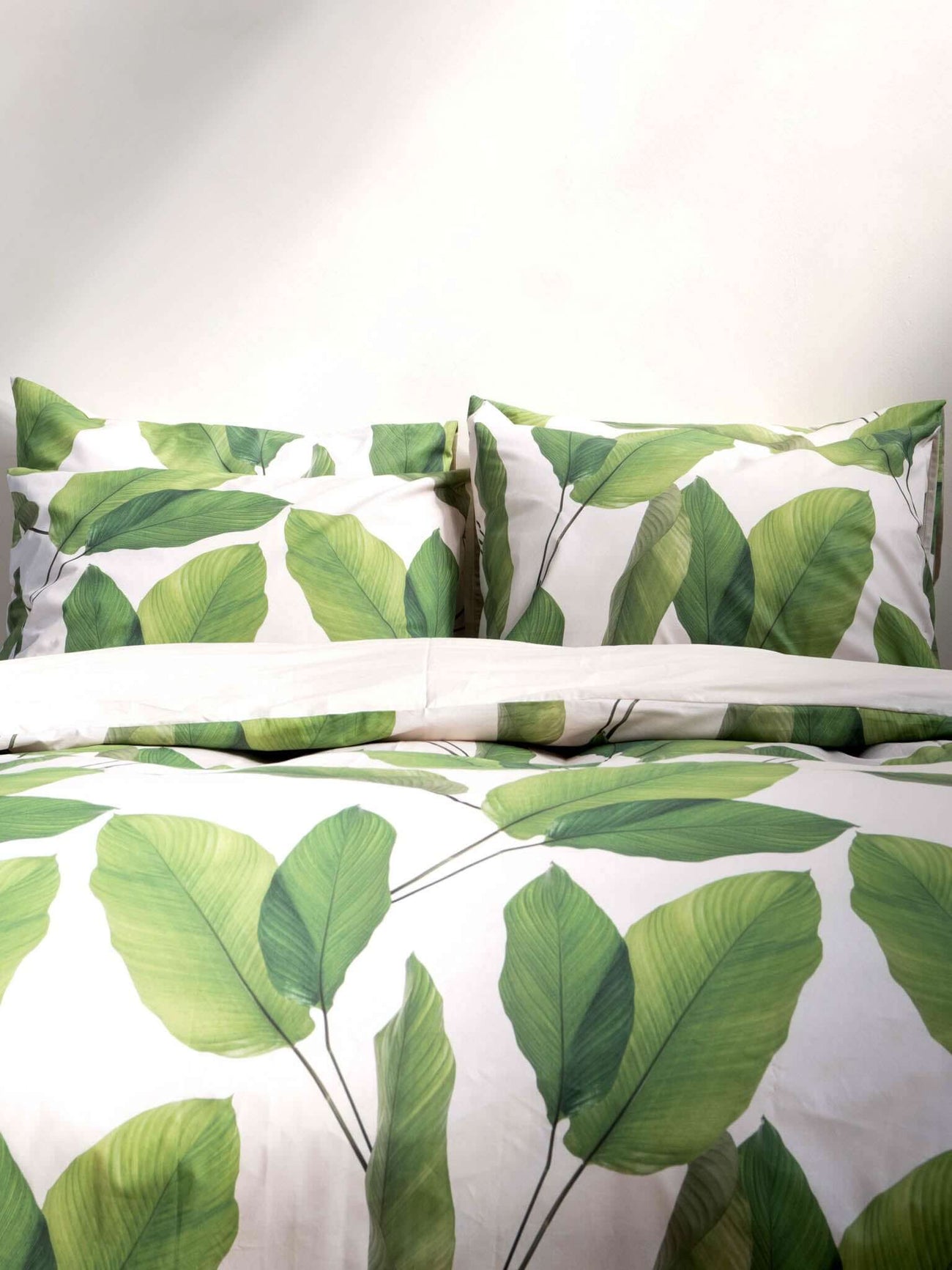 SNURK Leaf Me dekbedovertrek met bladerenprint op dekbed en kussens.