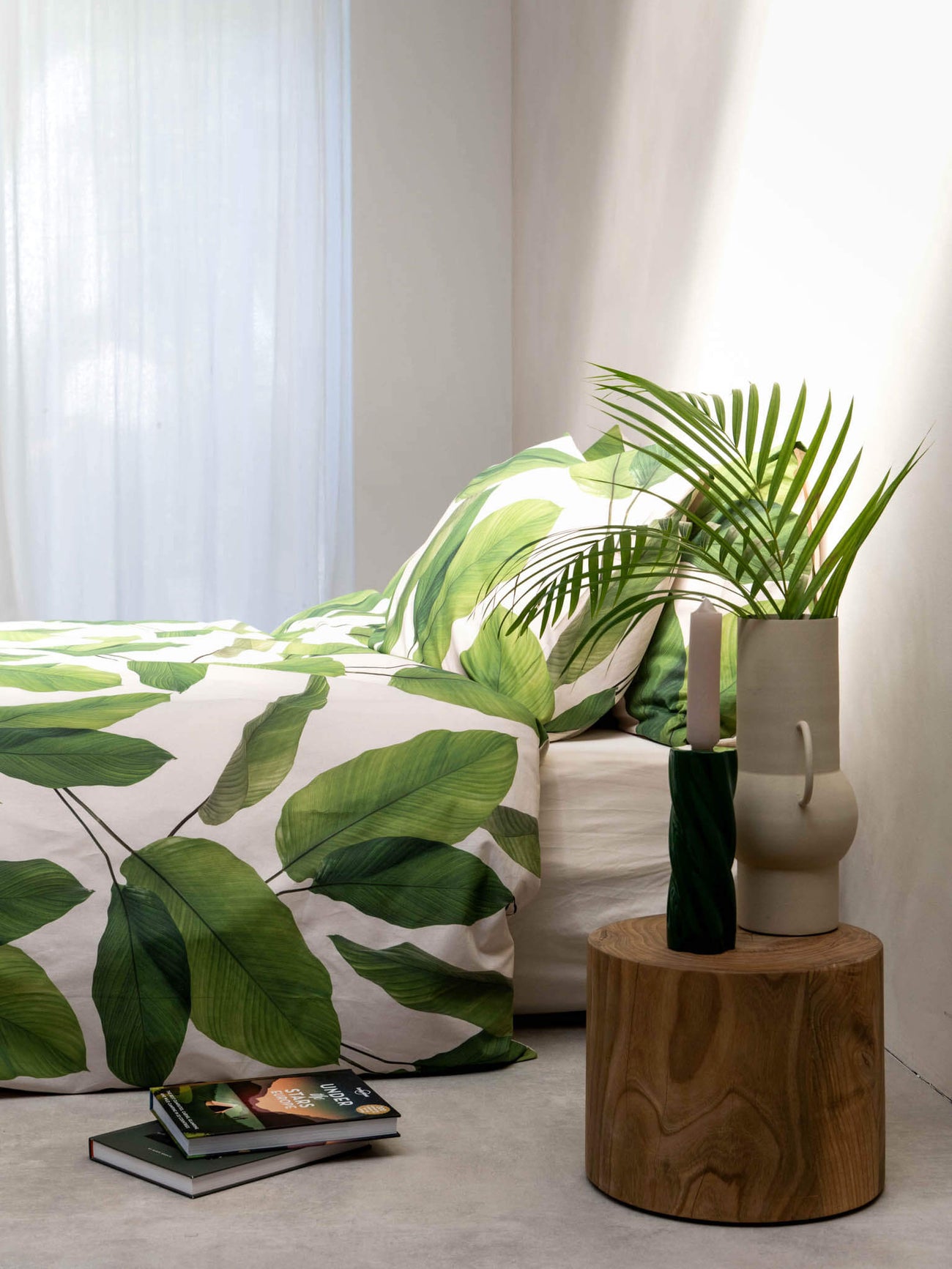 SNURK Leaf Me dekbedovertrek met bladerenprint op bed en decoratieve planten.