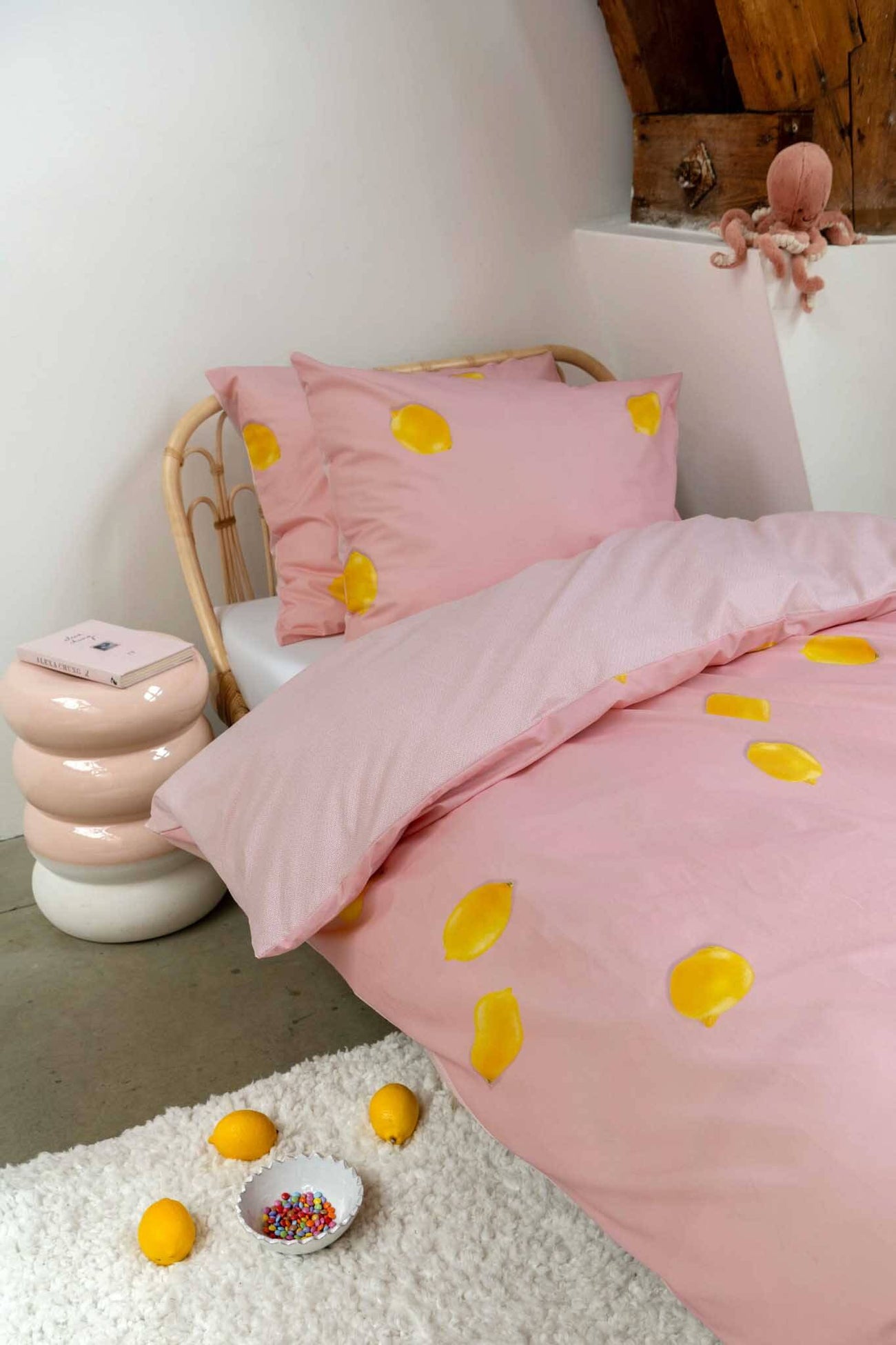 SNURK Lemon dekbedovertrek met citroenen op een roze ondergrond in een sfeervolle slaapkamer.
