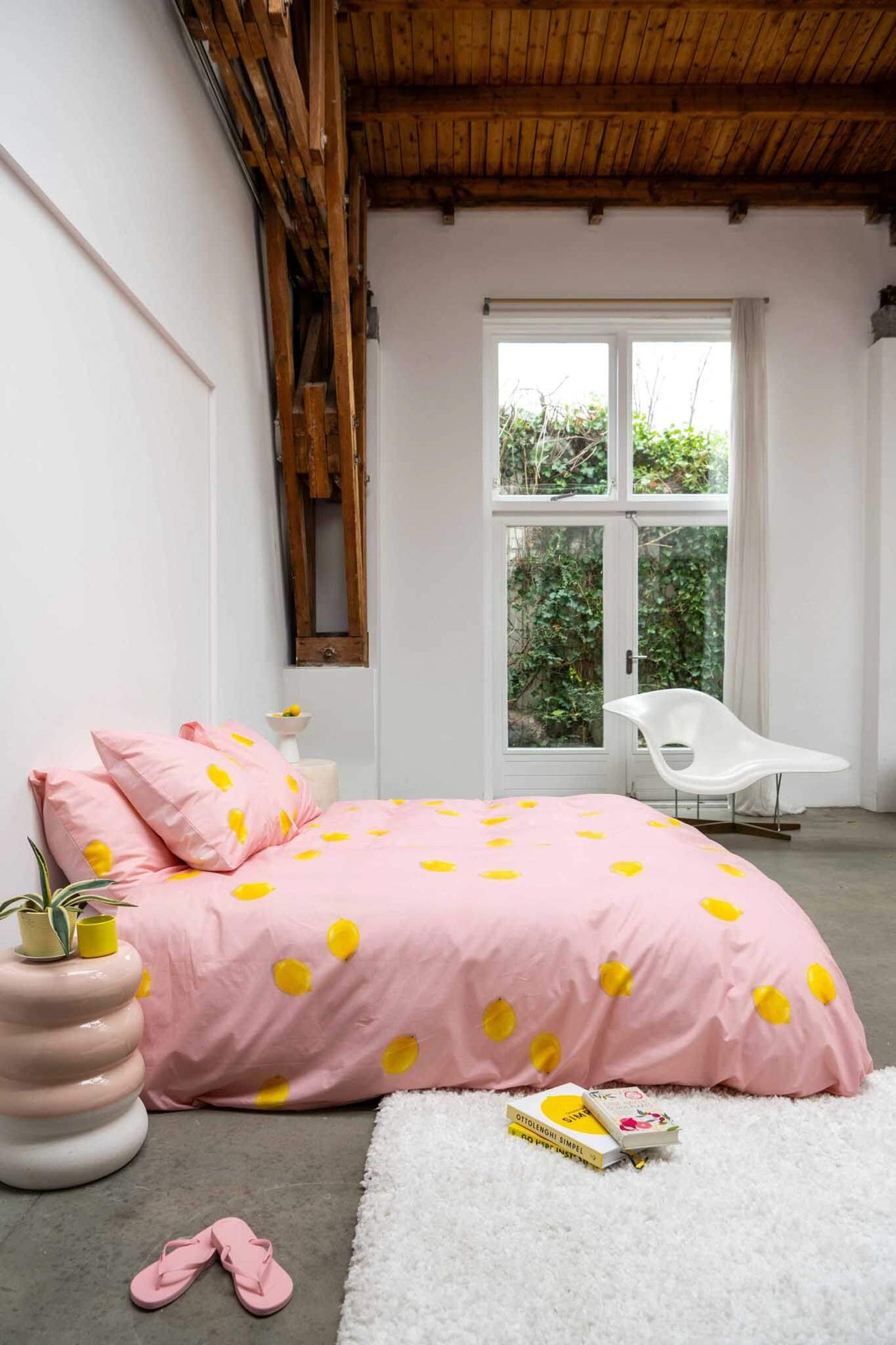 SNURK Lemon dekbedovertrek met gele citroenen op een roze dekbed in een moderne slaapkamer.