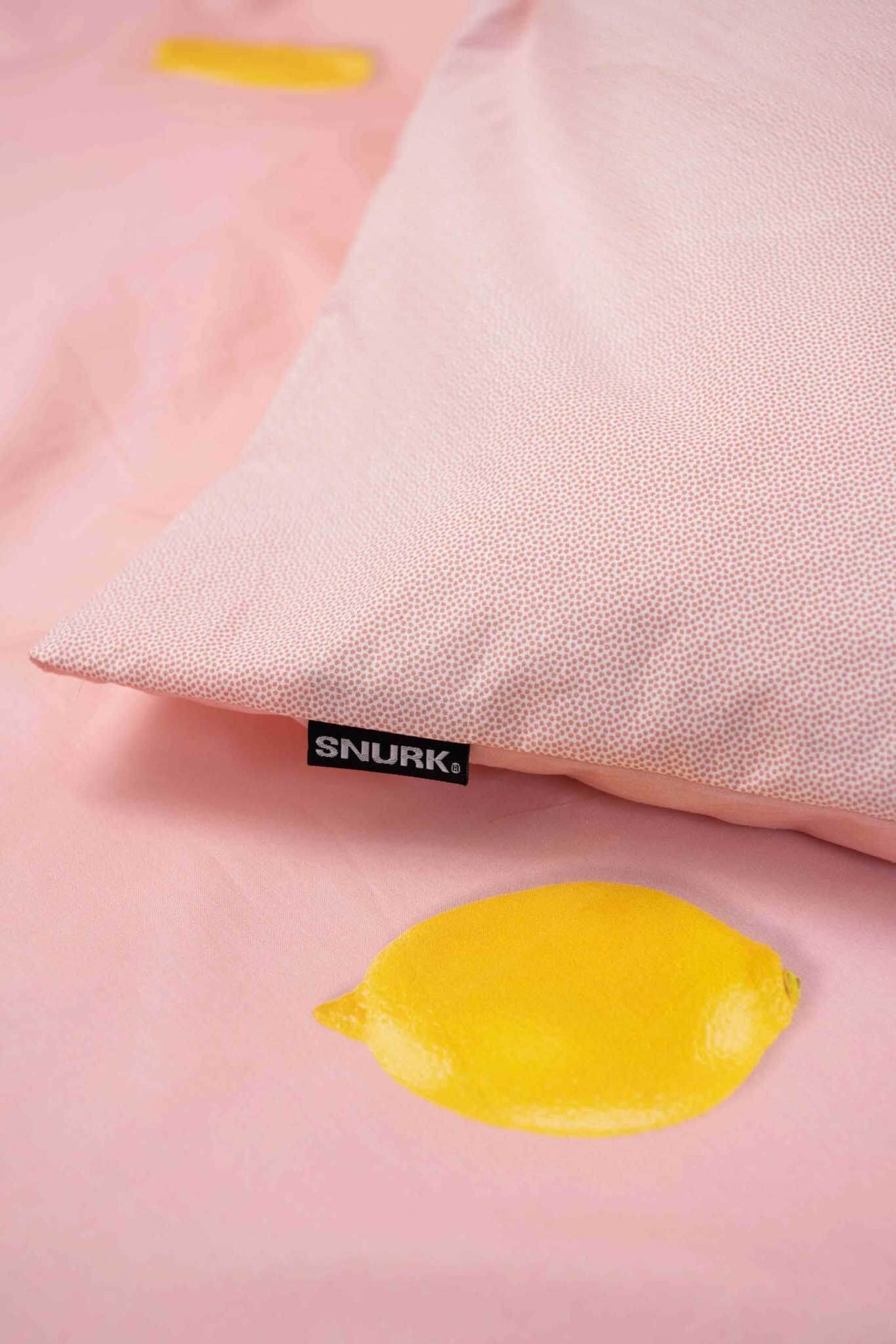 SNURK Lemon dekbedovertrek met vrolijke citroenen op een roze achtergrond, gemaakt van 100% biologisch katoen.