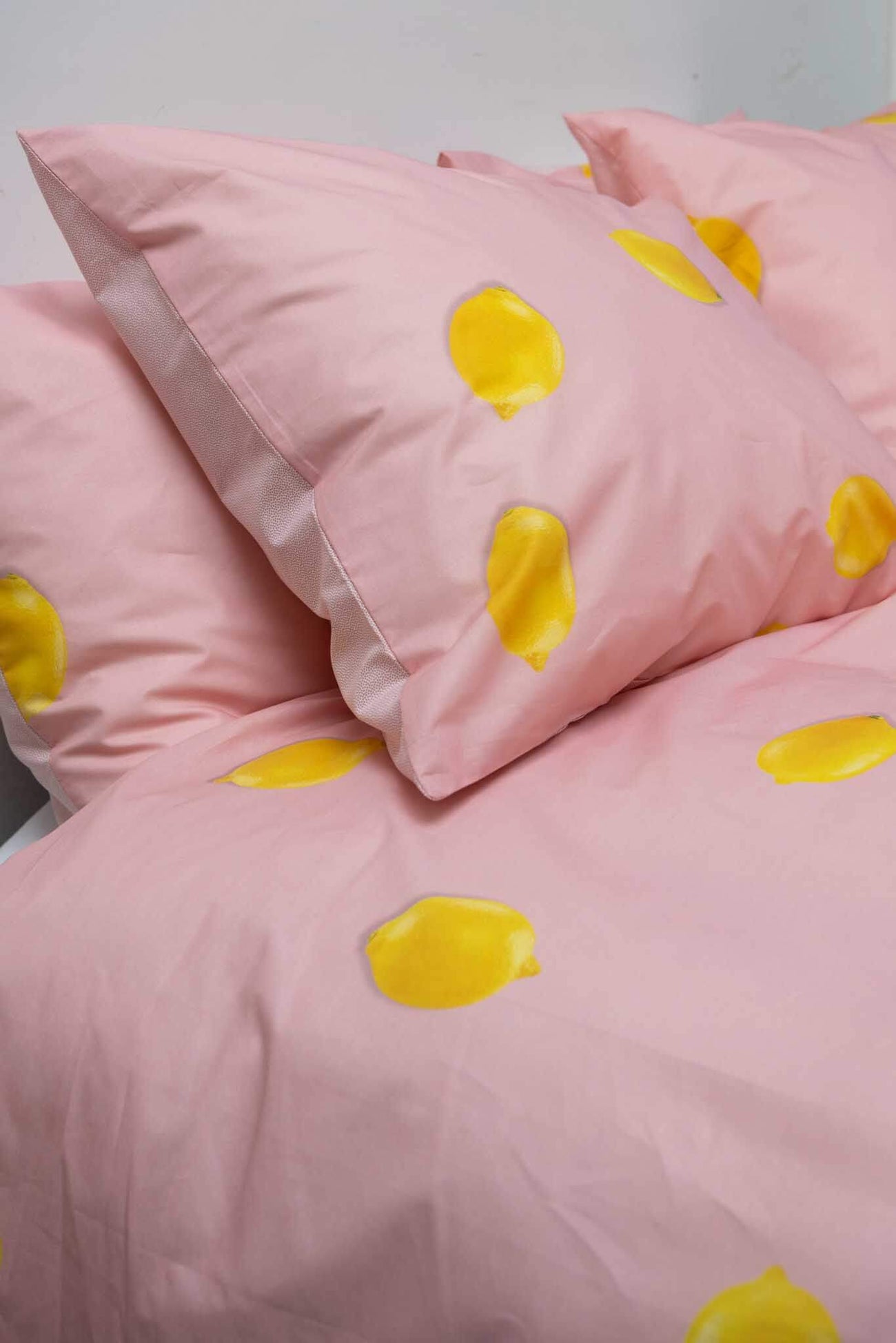 SNURK Lemon dekbedovertrek met knalgele citroenen op een roze ondergrond voor een vrolijke slaapkamer.