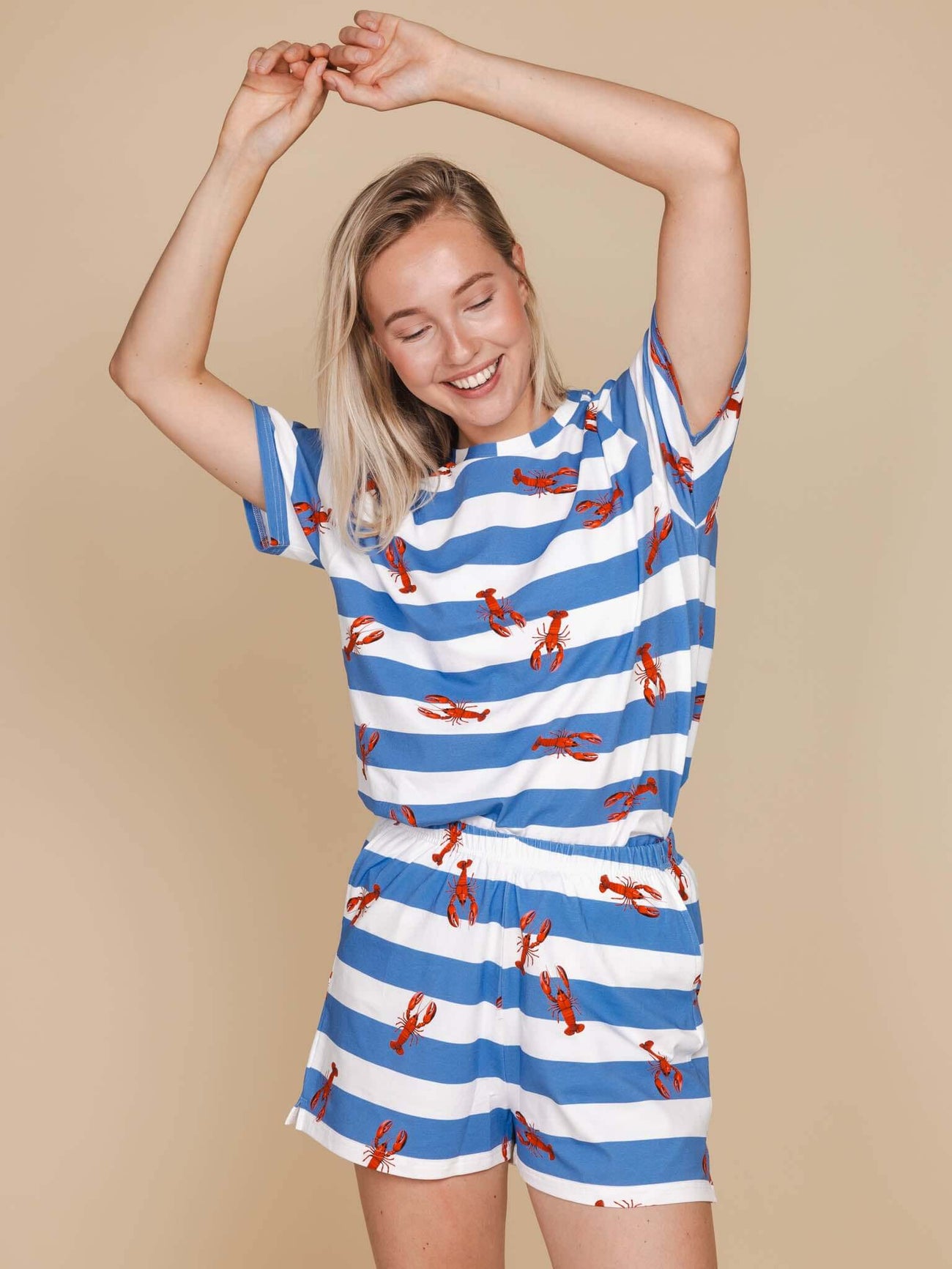 Model in SNURK Lobsters Shorts Dames met blauwe strepen en kreeftenpatroon, perfect voor loungen en slapen.