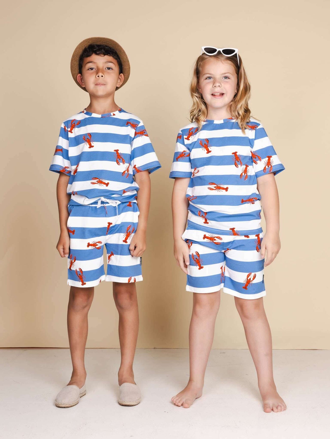 SNURK Lobsters T-shirt Kids gedragen door kinderen in blauw gestreepte outfit met kreeftjes.