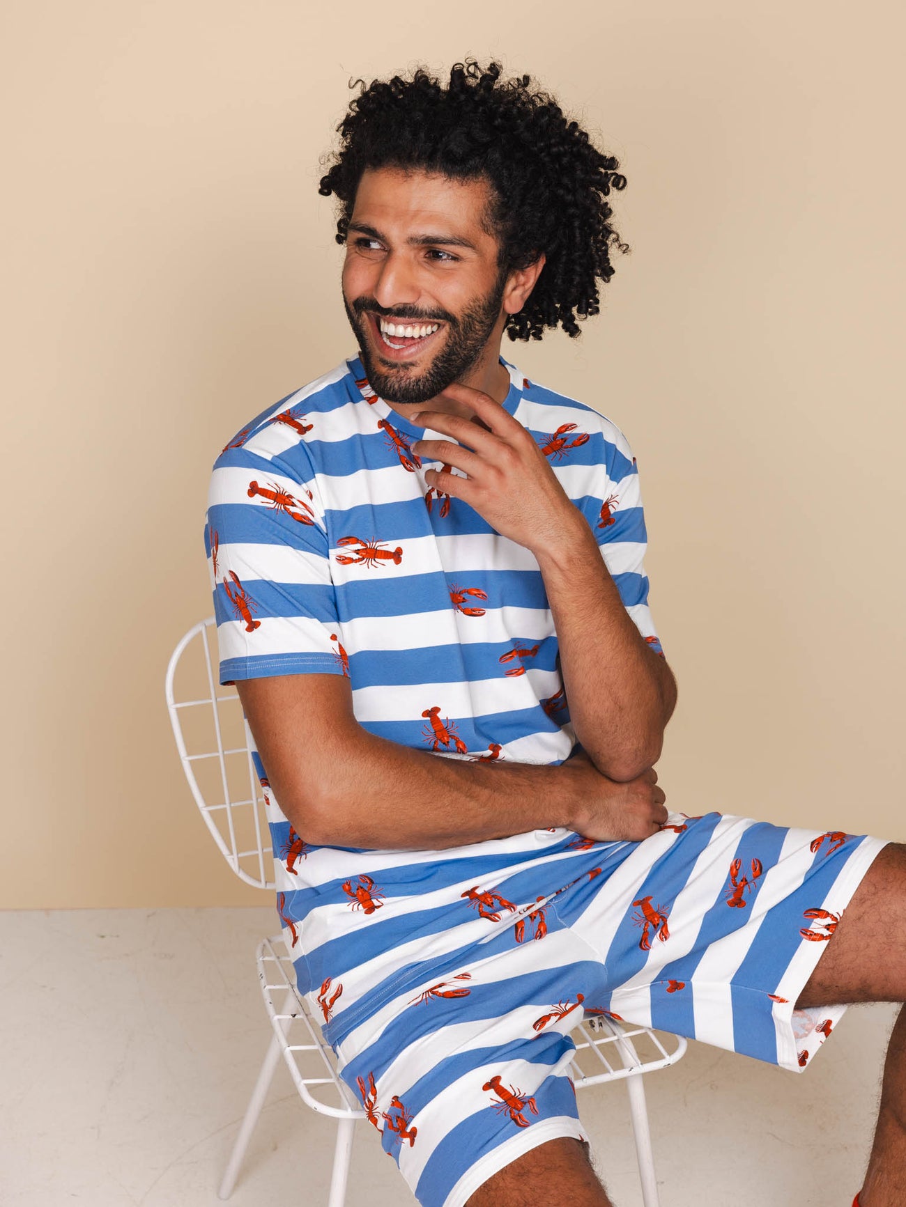 SNURK Lobsters T-shirt Unisex met kreeftjes op blauw gestreepte ondergrond, gedragen door een man.