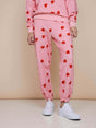 SNURK Lollipop Love Broek Relaxed Unisex met felrode hartjeslollies op roze.