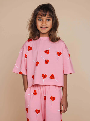SNURK Lollipop Love Cropped T-Shirt Kids in pink with red heart lollipops, perfect for cheerful playtime.