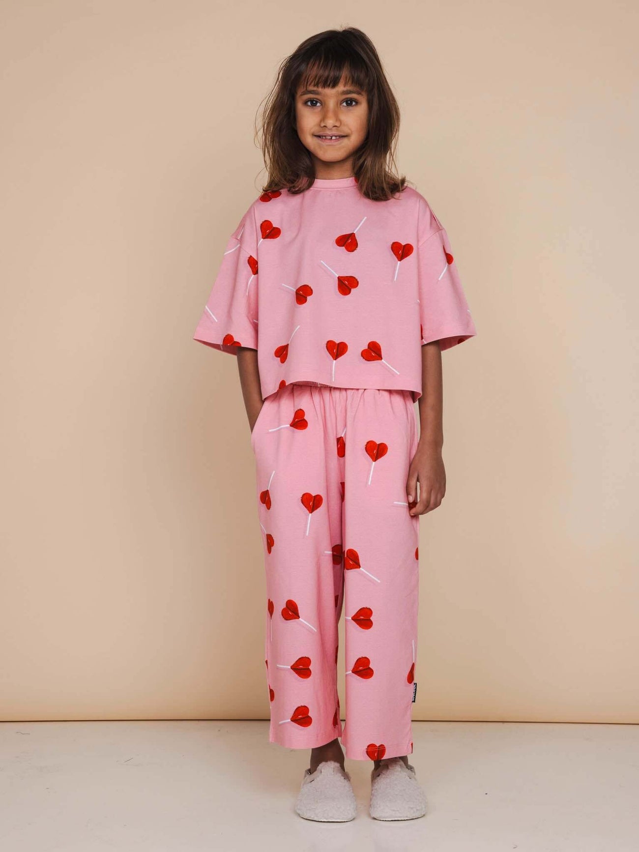 SNURK Lollipop Love Cropped T-Shirt Kids met vrolijke hartjeslollies op roze, perfect voor kinderen.