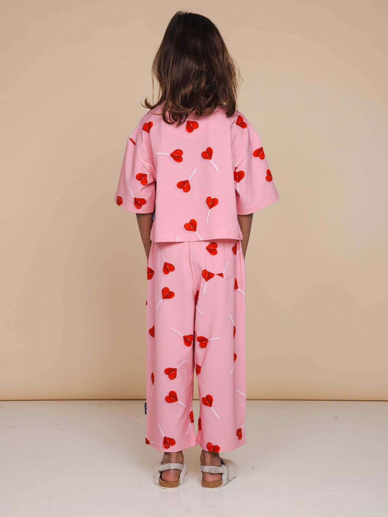 SNURK Lollipop Love Cropped T-Shirt Kids in pink with heart lollipops, perfect for playful and cozy days.