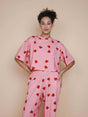SNURK Lollipop Love Cropped T-shirt Dames met schattige hartjeslollies op een roze achtergrond.