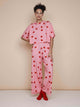SNURK Lollipop Love Cropped T-shirt Dames met hartjeslollies op roze, model poseert in comfortabele outfit.