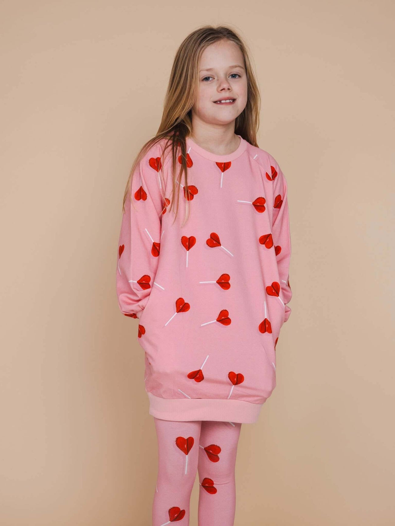SNURK Lollipop Love Legging Kids in pink with red heart lollipops, perfect for playful comfort and good vibes.