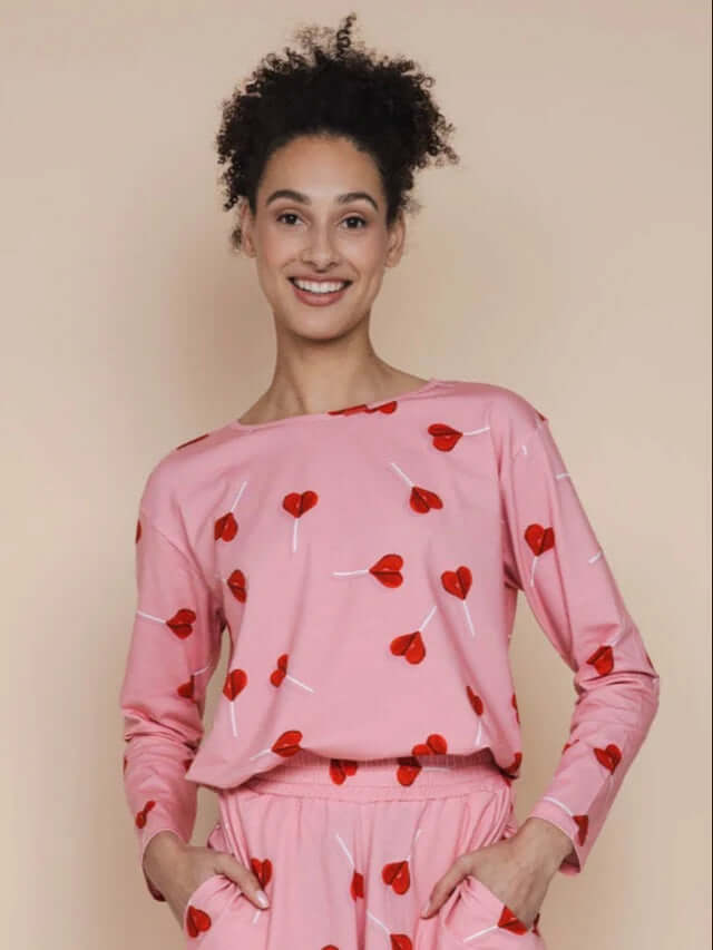 SNURK Lollipop Love Long Sleeve T-shirt Dames met felrode hartjeslollies op een roze achtergrond.