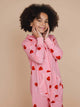SNURK Lollipop Love Onesie Kids in roze met hartjeslollies op een kind met een vrolijke uitstraling.