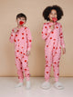 Kinderen in SNURK Lollipop Love Onesie Kids met hartjeslollies op een roze achtergrond.