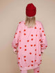Achterkant van de SNURK Lollipop Love Sweater Dress Dames met hartjeslollies op een roze achtergrond, casual look.
