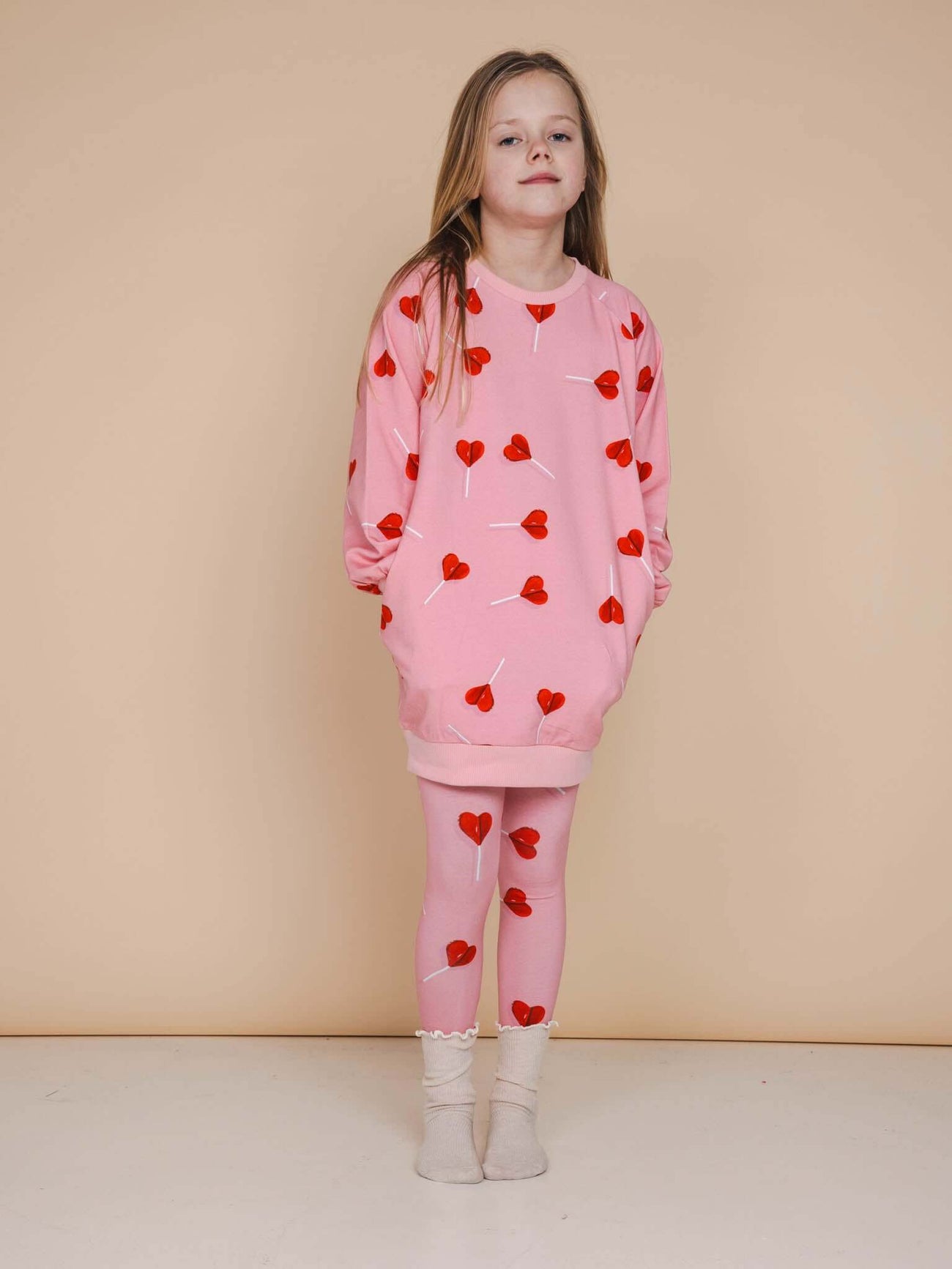 SNURK Lollipop Love Sweater Dress Kids in pink with heart lollipops, perfect for kids' casual wear.