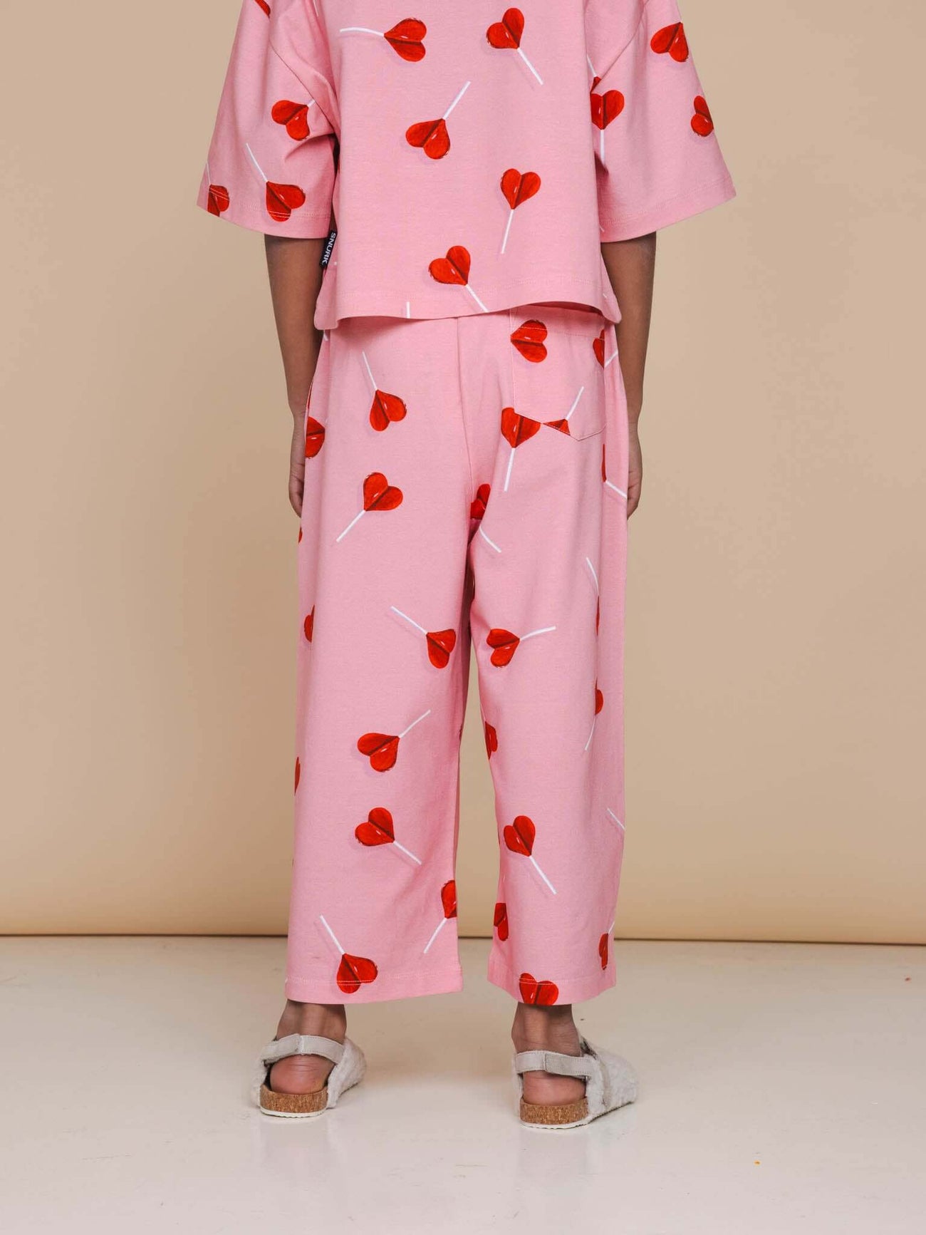 SNURK Lollipop Love Wijde broek Kids, vrolijke wijde broek met hartjeslollies, gemaakt van biologisch katoen.