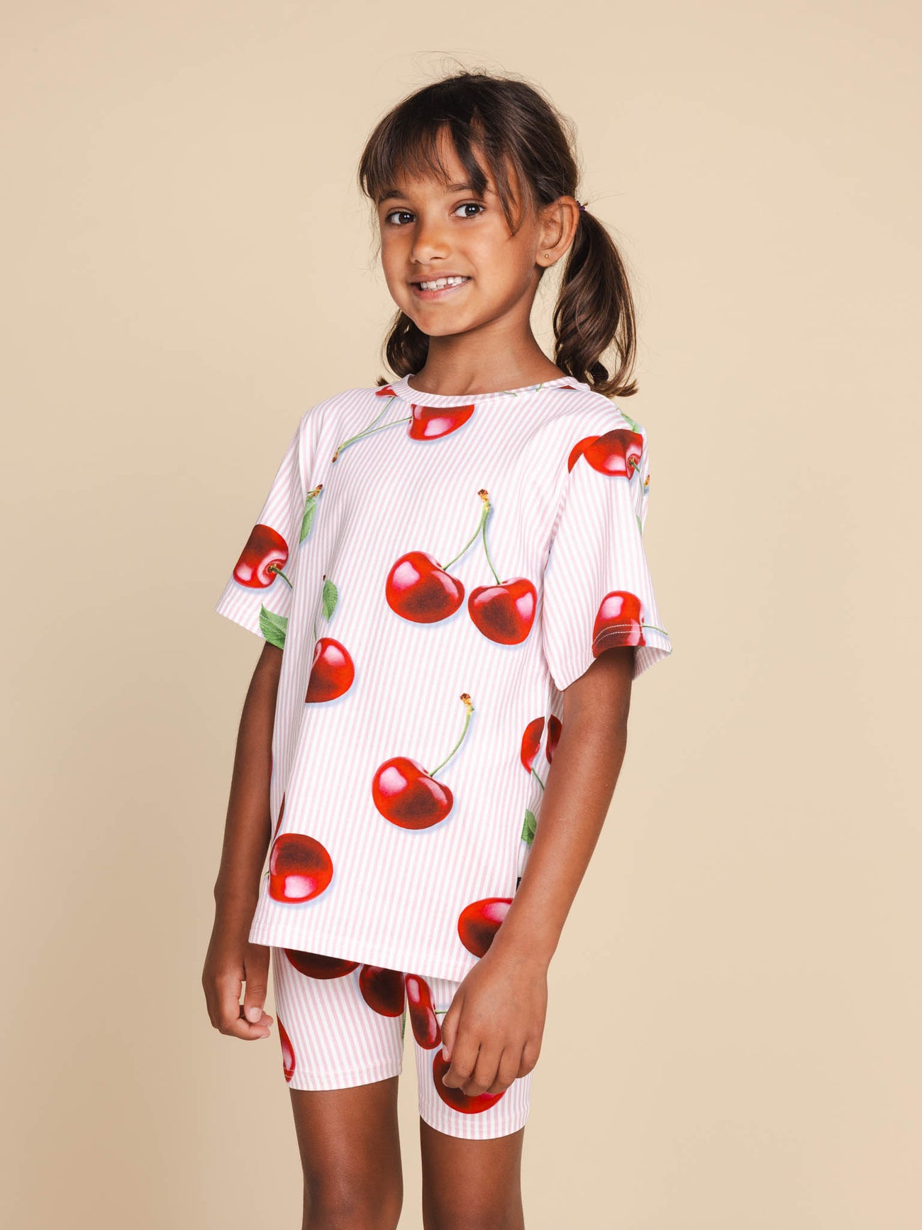 Kind met SNURK Mon Cherry Bikershorts Kids en tshirt met rode kersjes, sportieve look.