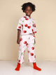 Kind in SNURK Mon Cherry Cropped T-Shirt Kids met kersjesprint, geniet van een comfortabele en schattige look.
