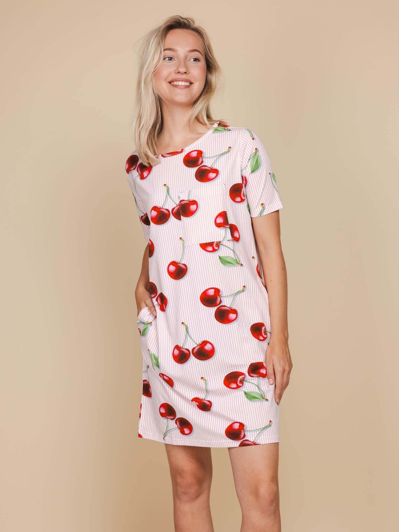 SNURK Mon Cherry T-shirt Dress Dames met print van rode kersjes op een beige achtergrond.
