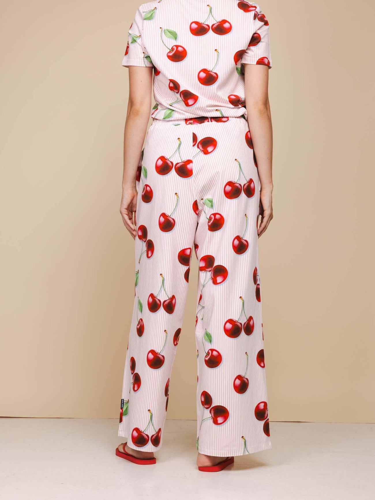 SNURK Mon Cherry Wijde Broek Dames met rode kersenprint in relaxte fit en wijde pijpen, gezien van achteren.