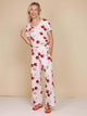 SNURK Mon Cherry Wijde Broek Dames in zachte katoen met kersenprint en wijde pijpen, model met vrolijke glimlach.