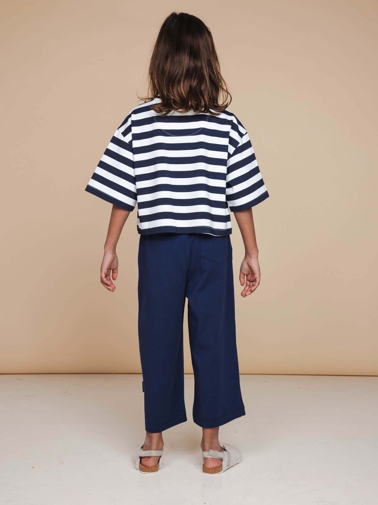 SNURK Navy Wijde broek Kids achteraanzicht met gestreept T-shirt op een neutrale achtergrond.