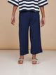 Achteraanzicht van een kind in een gestreepte top en SNURK Navy Wijde broek Kids, comfortabel en stijlvol met wijde pijpen.