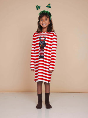 Meisje in SNURK Pierre Xmas Long Sleeve Dress Kids met kersthoofdtooi in een sfeervolle setting.
