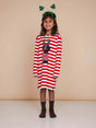 Meisje in SNURK Pierre Xmas Long Sleeve Dress Kids met kersthoofdtooi in een sfeervolle setting.