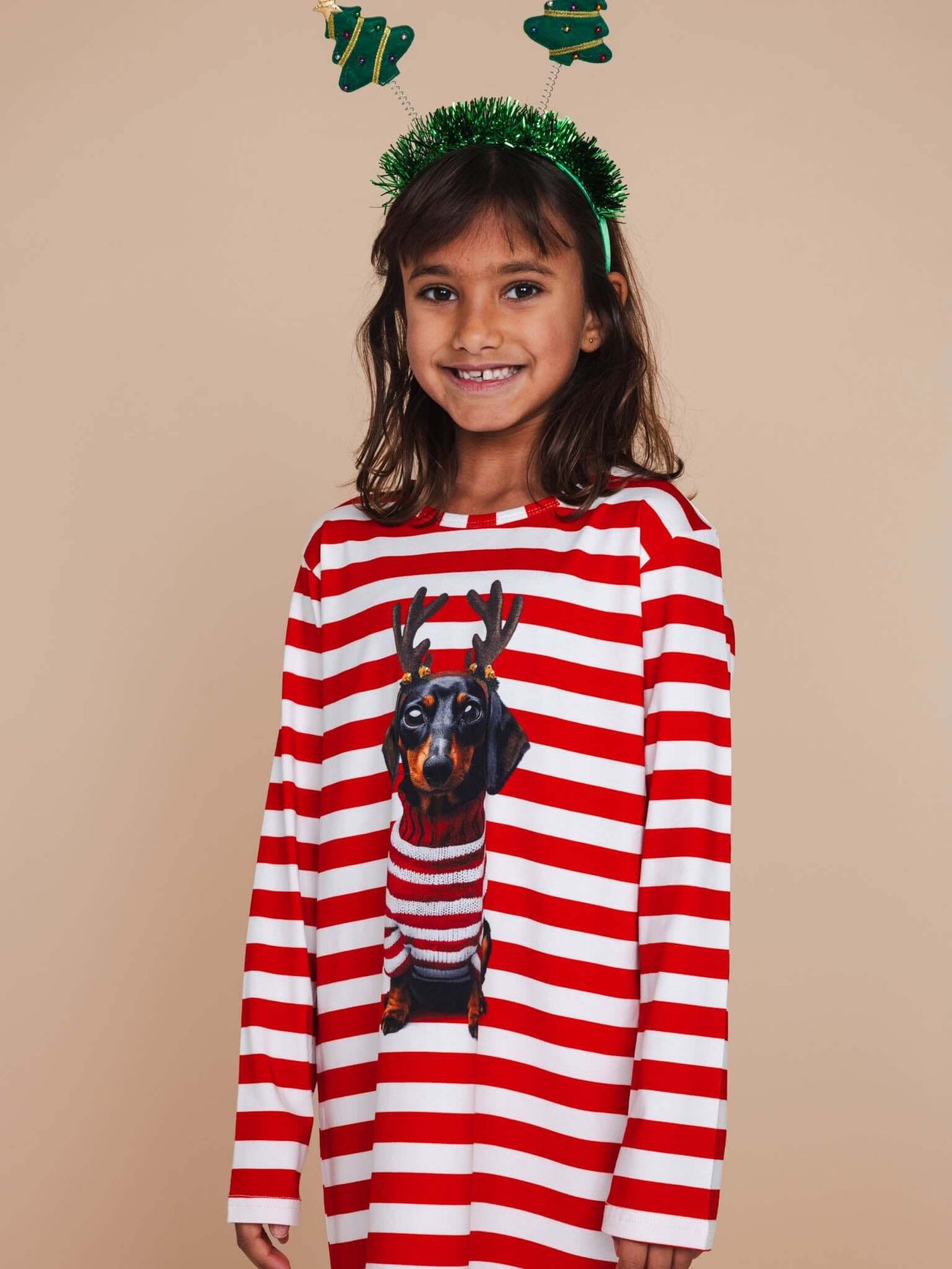 Kind in SNURK Pierre Xmas Long Sleeve Dress Kids met gestreepte ontwerp en dachshund print voor kerstmis.