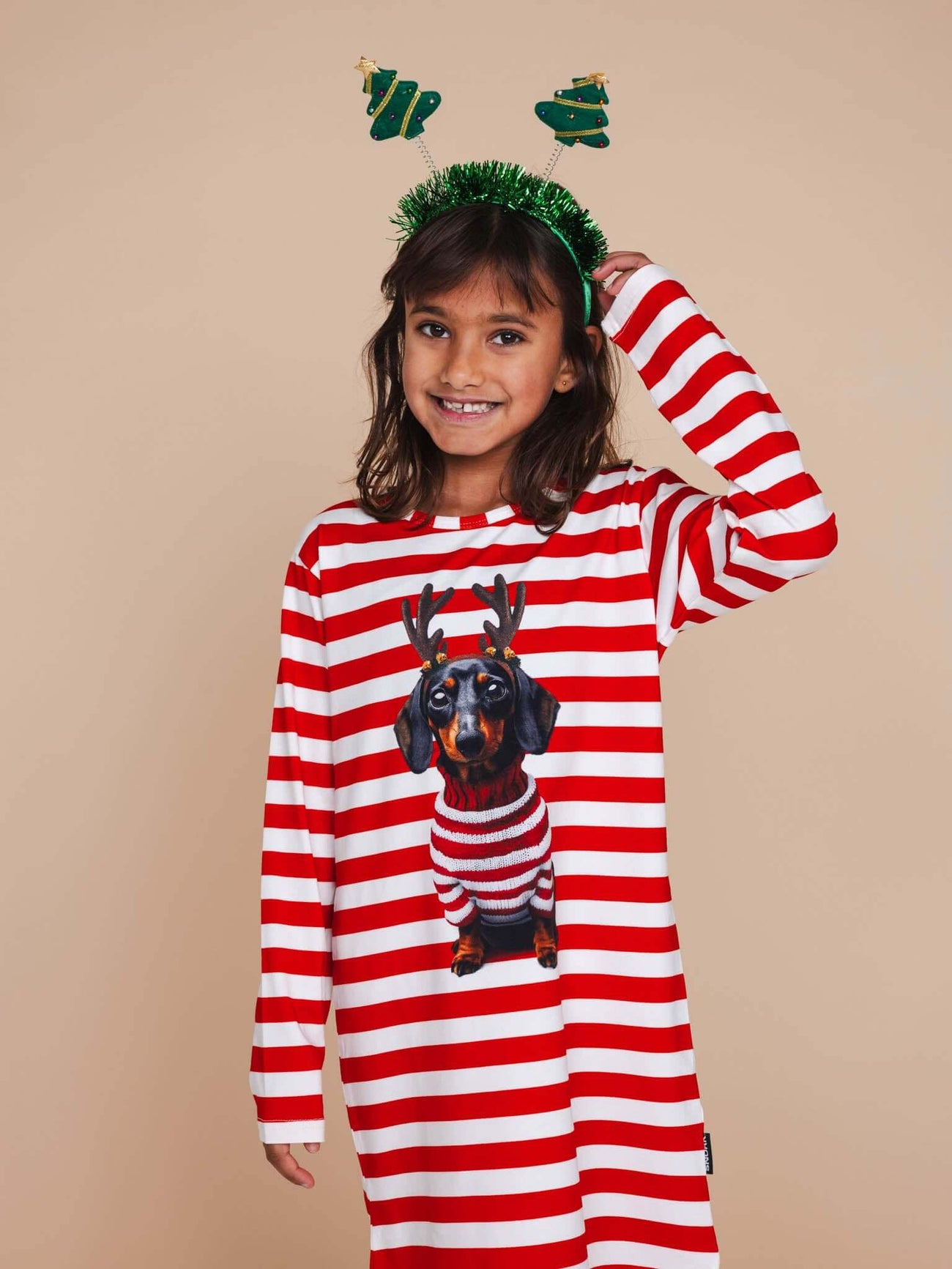 Kind in SNURK Pierre Xmas Long Sleeve Dress Kids met gestreepte mouwen en kersthoed.