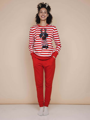 SNURK Pierre Xmas Sweater Dames model in gestreepte sweater met hond en rode broek, perfect voor de feestdagen.