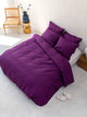 SNURK Plum Purple dekbedovertrek op een bed met kussens, duurzaam en ademend met een mooie paarse kleur.