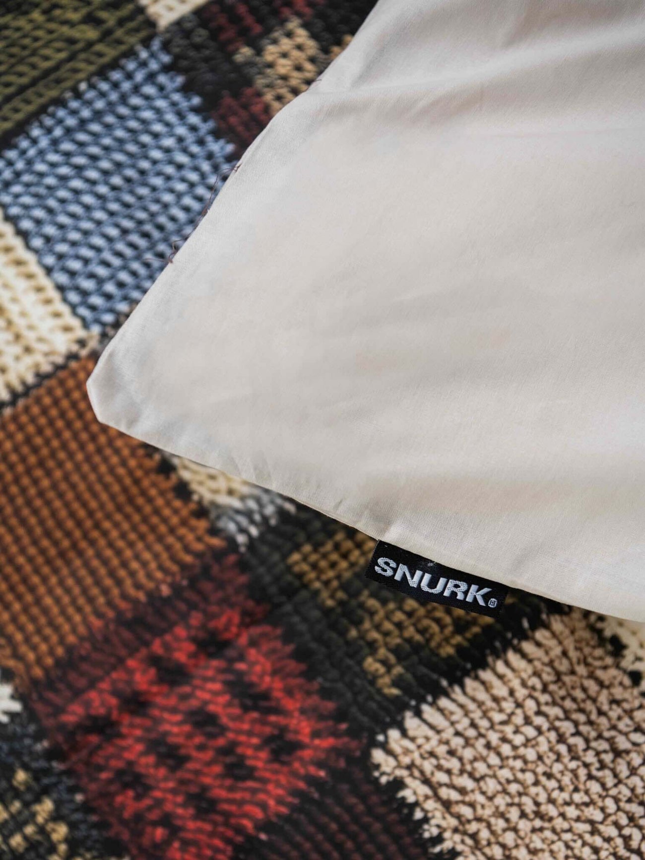 SNURK Quilty Pleasure dekbedovertrek op een kleurrijke achtergrond met een label zichtbaar.