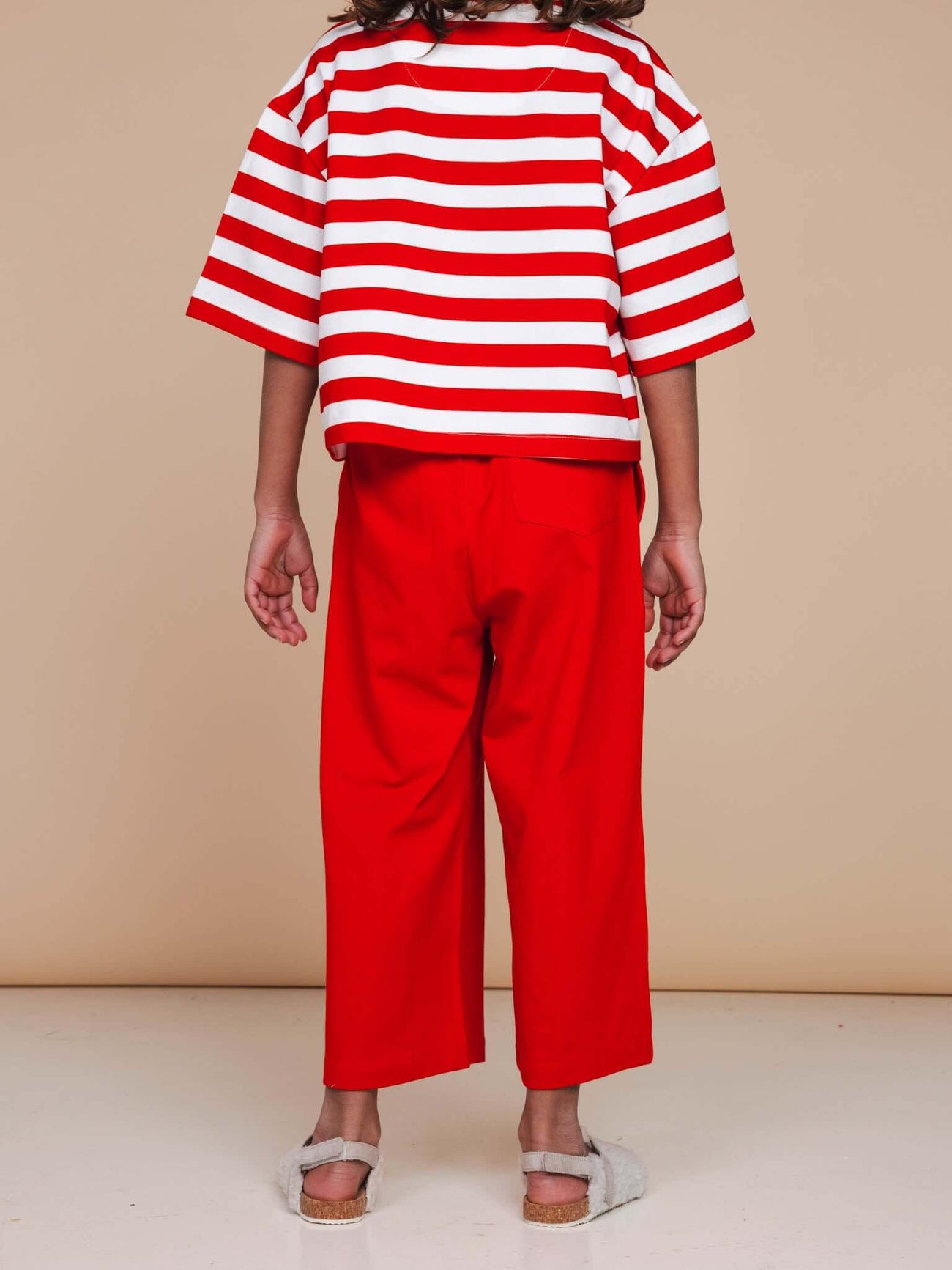 Meisje met opvallende rode wijde broek en gestreept shirt, stijlvol en comfortabel, SNURK Red Wijde broek Kids.