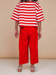 Meisje met opvallende rode wijde broek en gestreept shirt, stijlvol en comfortabel, SNURK Red Wijde broek Kids.