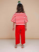 Achteraanzicht van een kind in een gestreepte top en SNURK Red Wijde broek Kids, met wijde pijpen en zachte stof.
