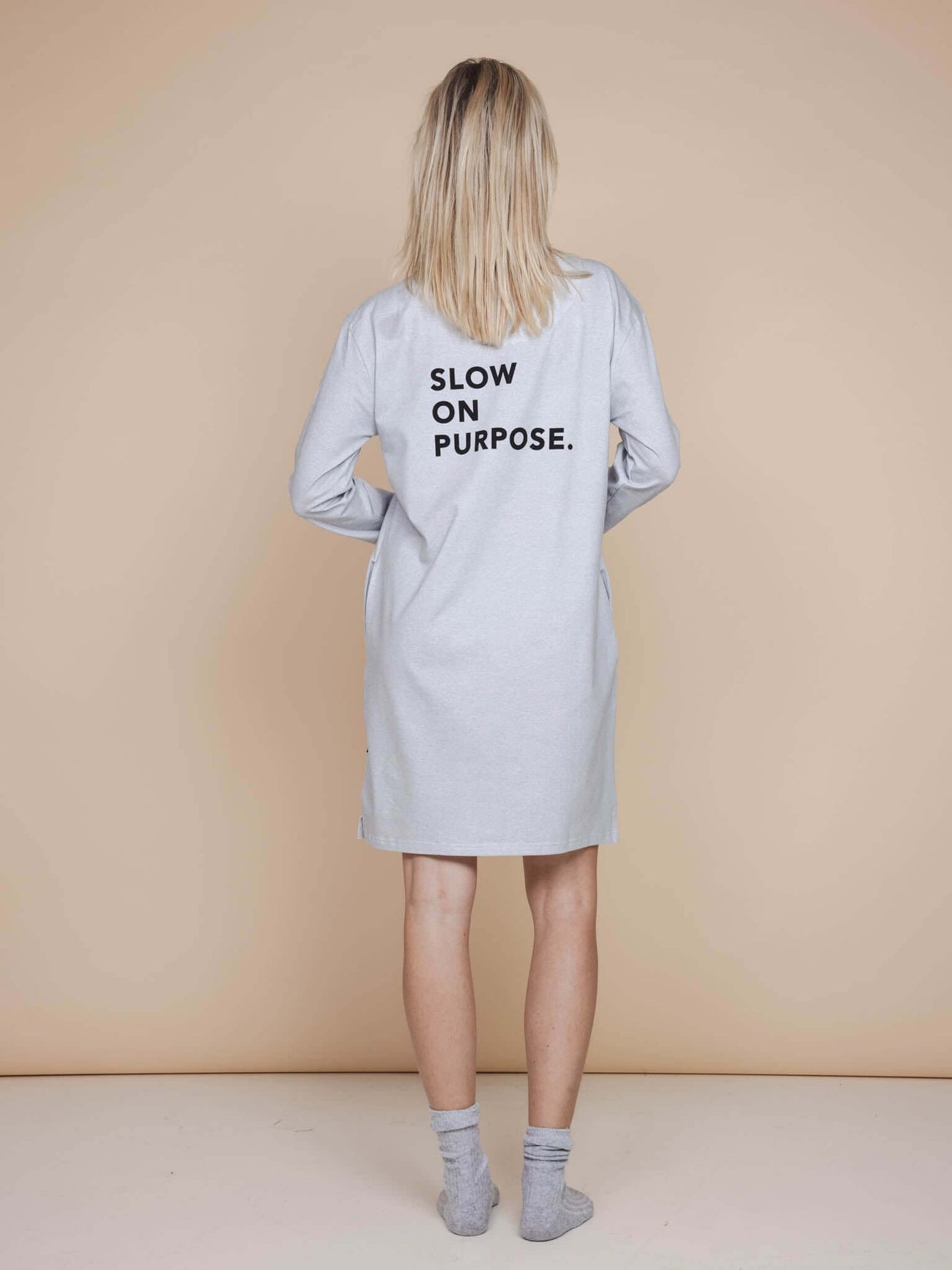 SNURK Slow Grey Long Sleeve Dress Dames met de slogan 'SLOW ON PURPOSE.' op de rug, relaxte pasvorm.