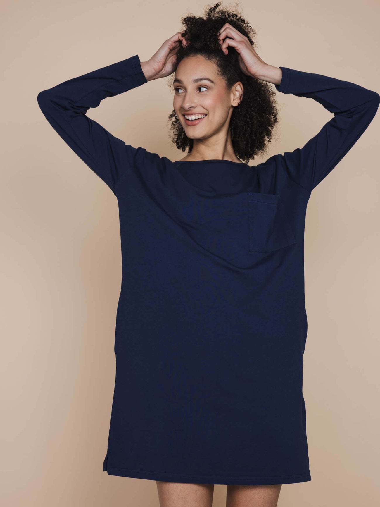 Vrouwelijk model in SNURK Slow Navy Long Sleeve Dress Dames, donkerblauw nachthemd met praktische zakken.