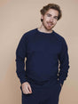 SNURK Slow Navy Sweater Heren gedragen door man op een neutrale achtergrond.