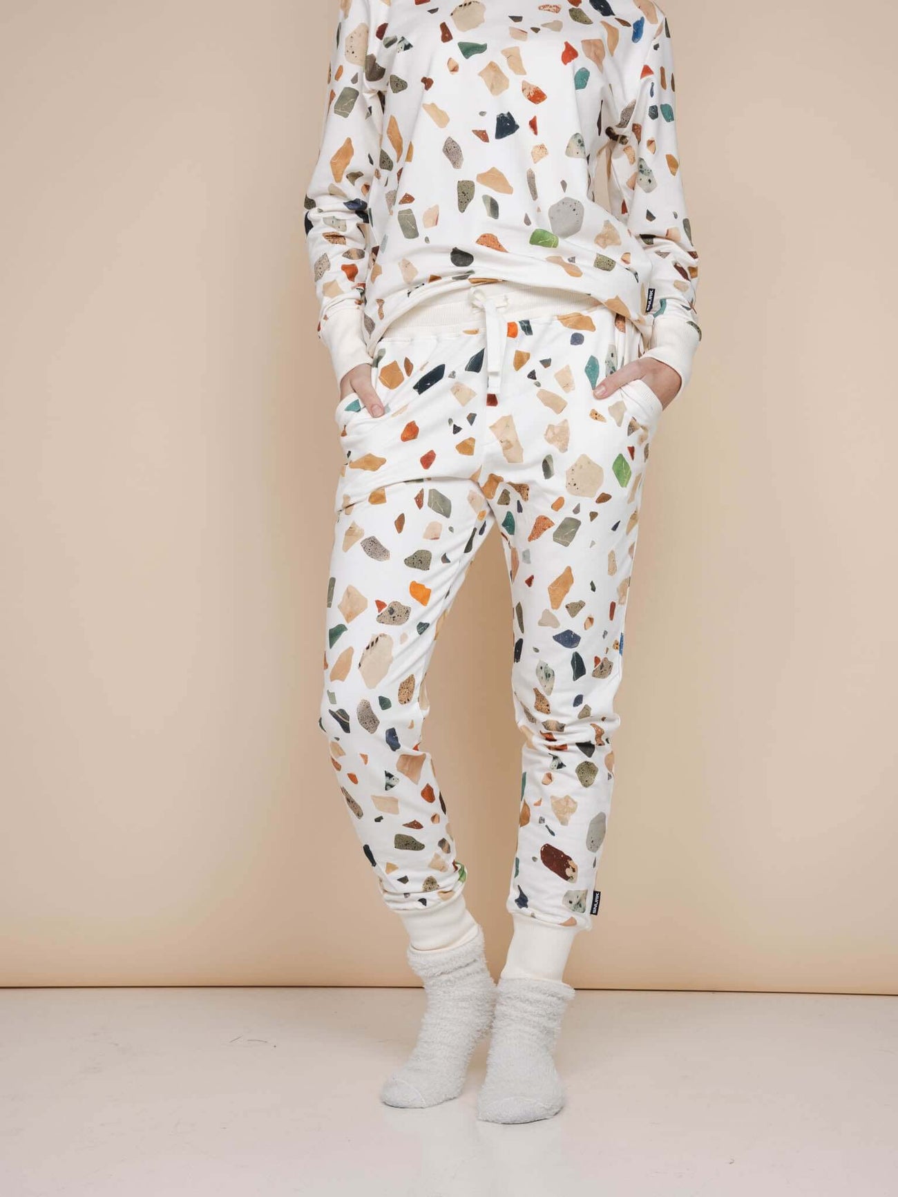 Dame in SNURK Terrazzo Broek Regular met speelse aardetinten en zacht materiaal, perfect voor thuis of na het sporten.