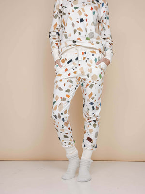 Dame in SNURK Terrazzo Broek Regular met speelse aardetinten en zacht materiaal, perfect voor thuis of na het sporten.