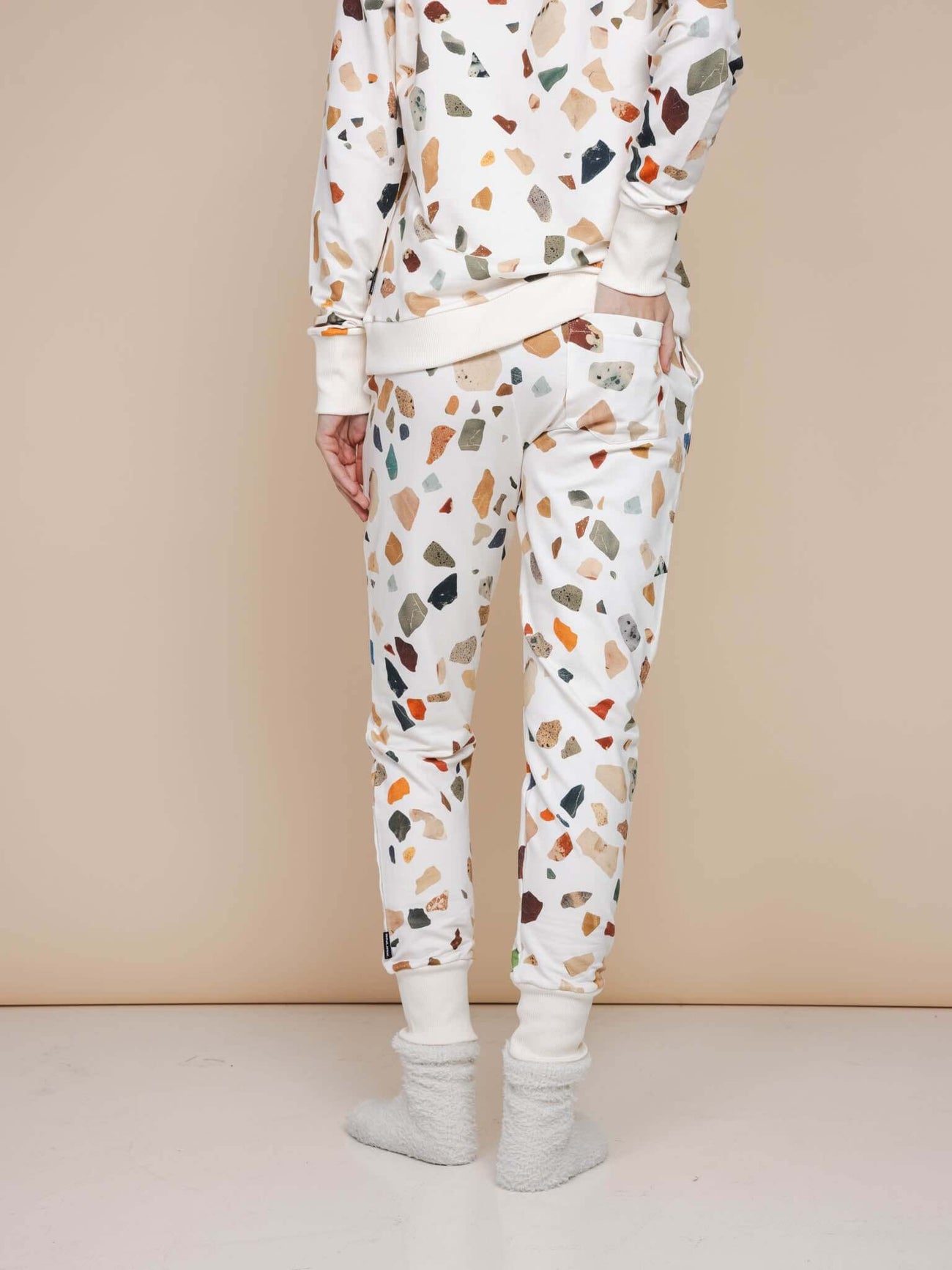 Model in SNURK Terrazzo Broek Regular met kleurrijke terrazzo print en zachte stof, perfect voor casual of sportieve outfits.