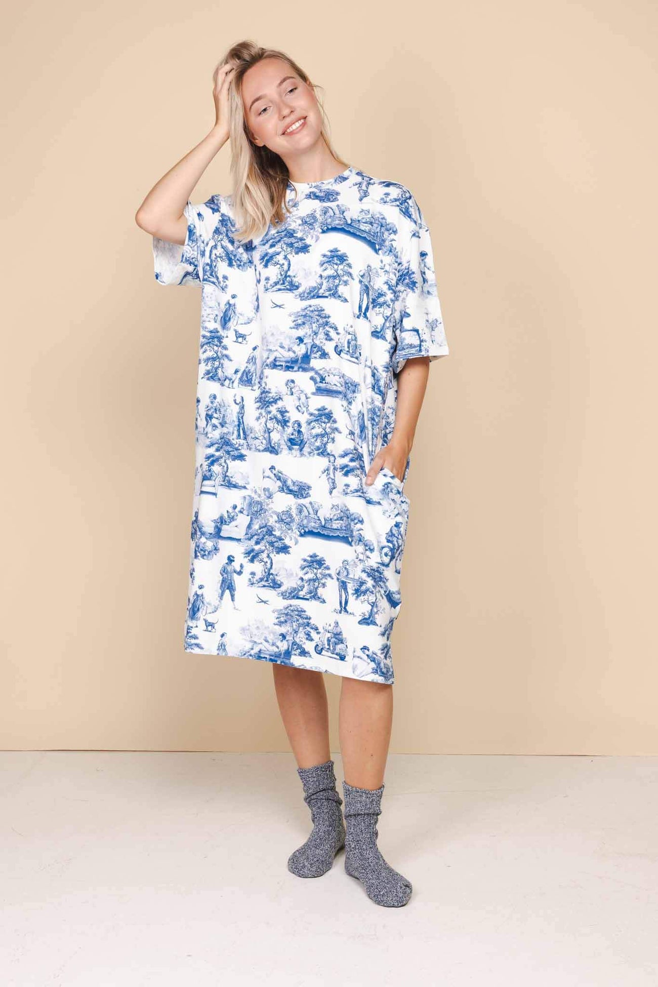 Model wearing SNURK Toile De Modern Joy Relaxed Tee Dress Dames, oversized blauw-witte jurk met klassiek Frans motief.