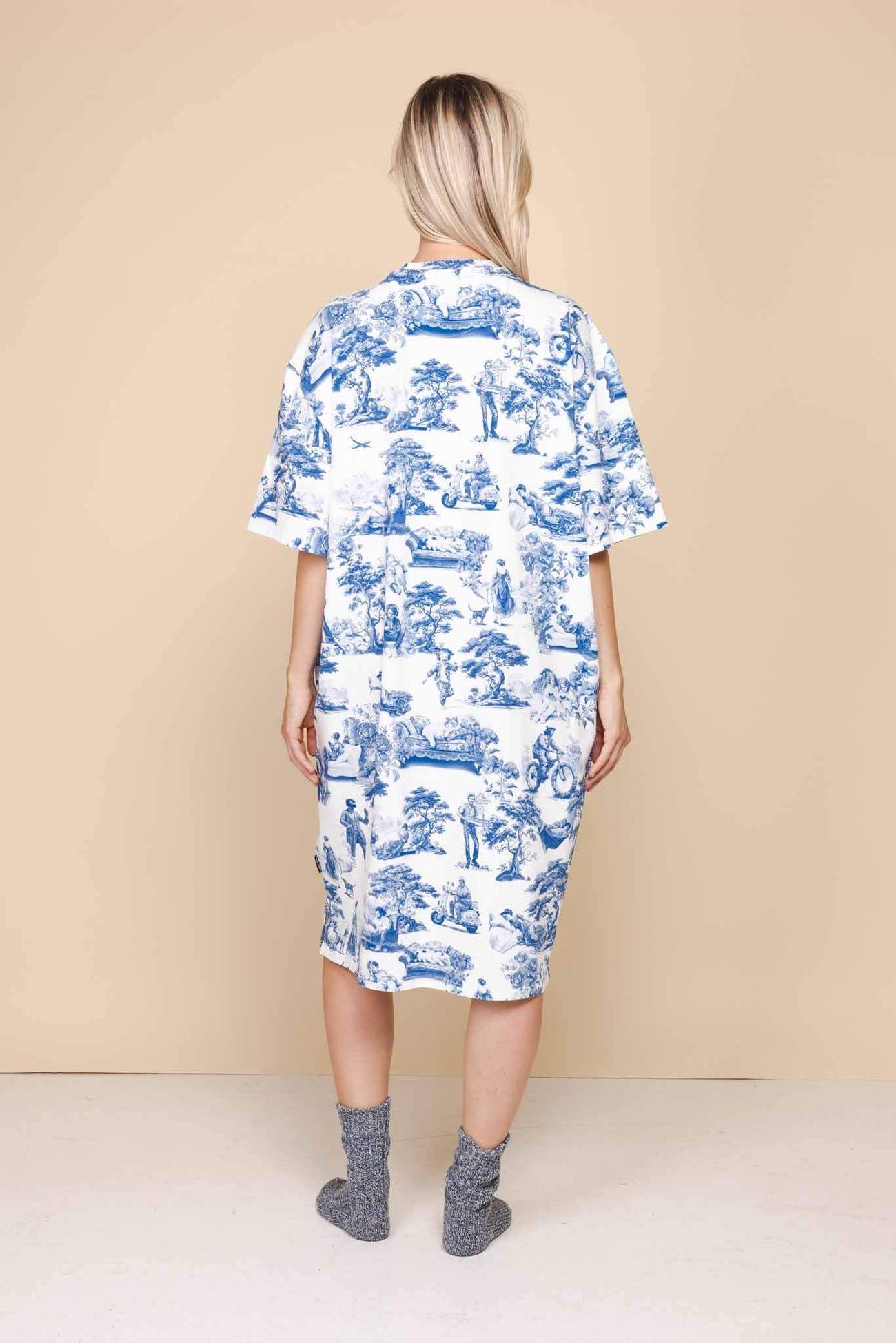 Achterzijde van de SNURK Toile De Modern Joy Relaxed Tee Dress Dames met blauw-wit patroon, gedragen door een vrouw.